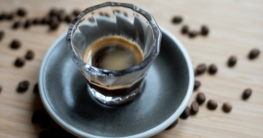 une tasse de café sur une table avec des grains